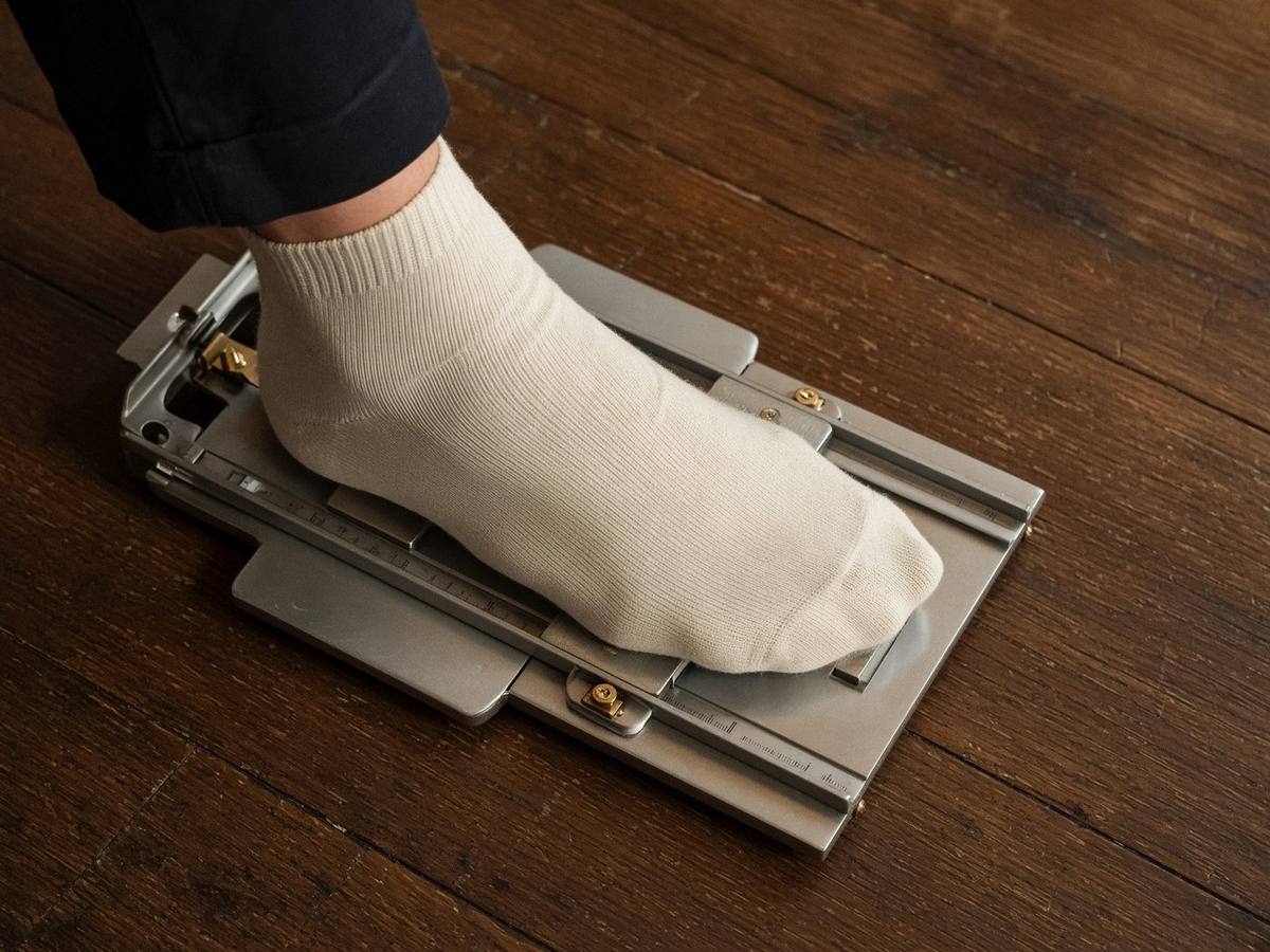 A foot being measured on a metal fitting device